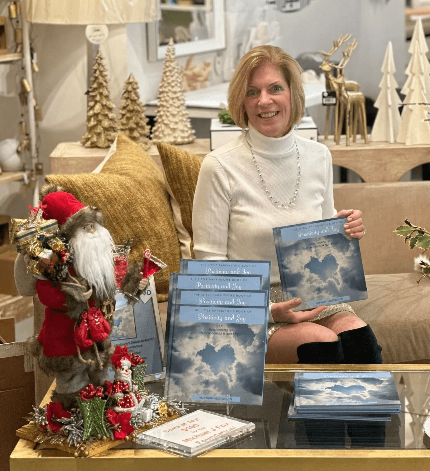 Kathleen Featherston holding her book at a signing event